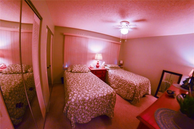 bedroom featuring two closets, a ceiling fan, carpet floors, and a textured ceiling