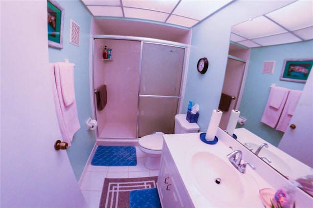 bathroom featuring tile patterned floors, toilet, a drop ceiling, and a shower stall