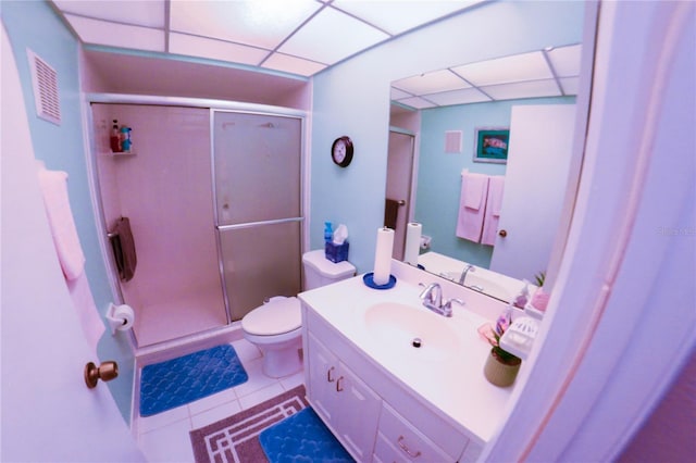 bathroom with tile patterned floors, visible vents, toilet, a stall shower, and a drop ceiling