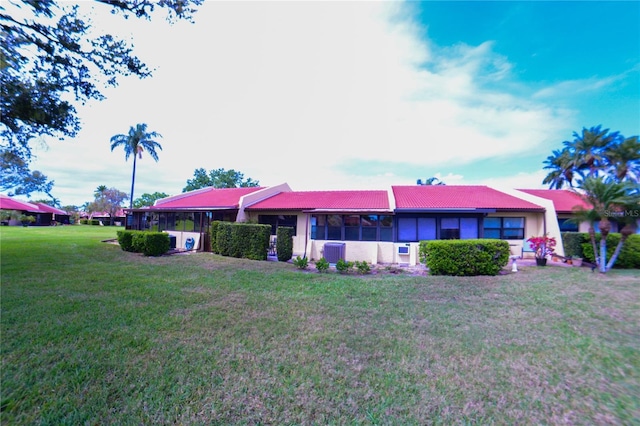 view of front of property with central air condition unit and a front lawn