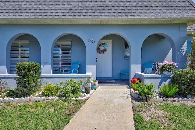 3807 41st Street Ct W Unit 52, Bradenton, FL 34205 - view of exterior entry featuring a shingled roof, mansard roof, and stucco siding