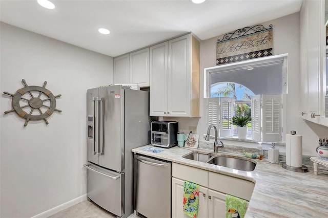 3807 41st Street Ct W Unit 52, Bradenton, FL 34205 - kitchen with baseboards, stainless steel appliances, white cabinetry, a sink, and light stone counters