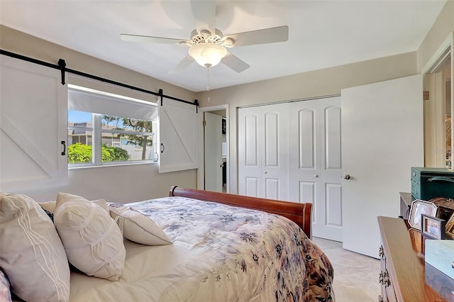3807 41st Street Ct W Unit 52, Bradenton, FL 34205 - bedroom with a ceiling fan, a barn door, light tile patterned flooring, and a closet