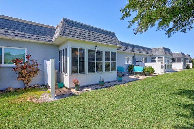 3807 41st Street Ct W Unit 52, Bradenton, FL 34205 - rear view of house with a lawn, a shingled roof, and mansard roof