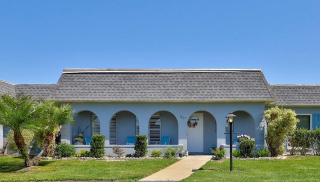 3807 41st Street Ct W Unit 52, Bradenton, FL 34205 - view of front of home featuring covered porch, roof with shingles, stucco siding, mansard roof, and a front lawn
