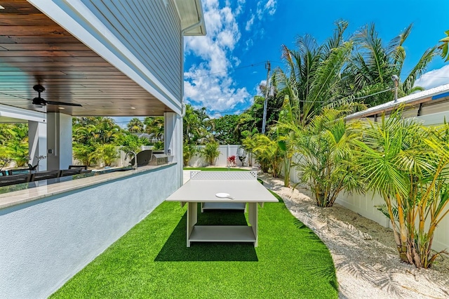 view of yard with a ceiling fan and a fenced backyard