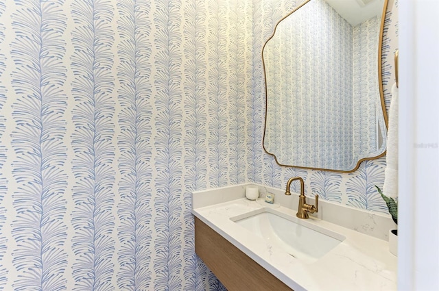 bathroom featuring wallpapered walls and vanity