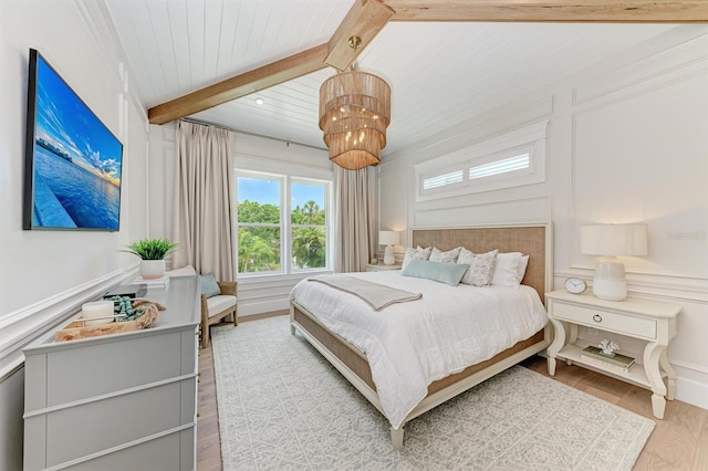 bedroom featuring wooden ceiling, a decorative wall, wood finished floors, and beamed ceiling