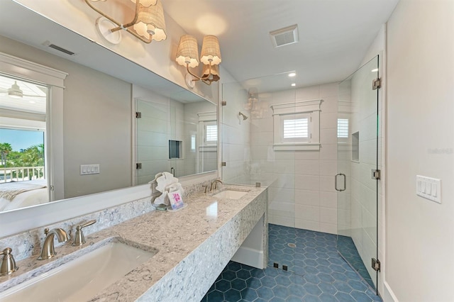 bathroom featuring visible vents, a stall shower, and a sink