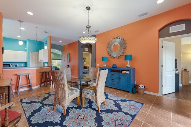 dining space with arched walkways, light tile patterned floors, visible vents, and recessed lighting