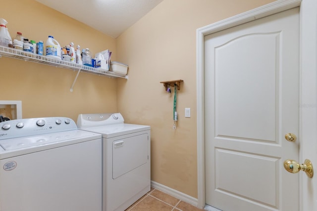 clothes washing area with laundry area, independent washer and dryer, light tile patterned flooring, and baseboards