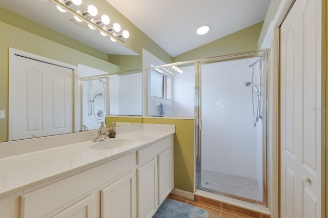 full bath featuring a stall shower, vanity, vaulted ceiling, and tile patterned floors