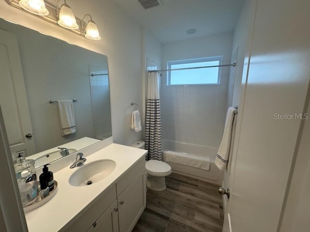 full bath featuring shower / tub combo with curtain, visible vents, toilet, vanity, and wood finished floors