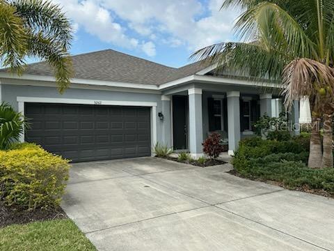 ranch-style home featuring concrete driveway, an attached garage, and stucco siding