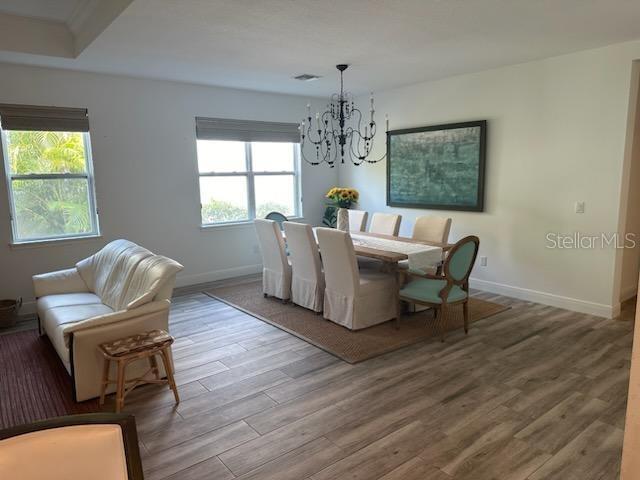 dining room featuring wood finished floors, a wealth of natural light, and baseboards