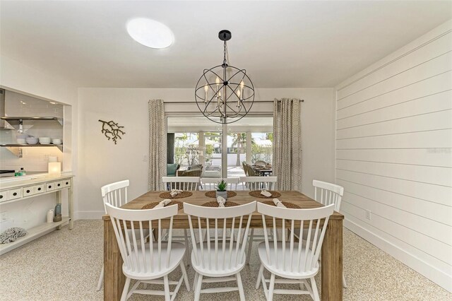 dining room with wooden walls and a chandelier