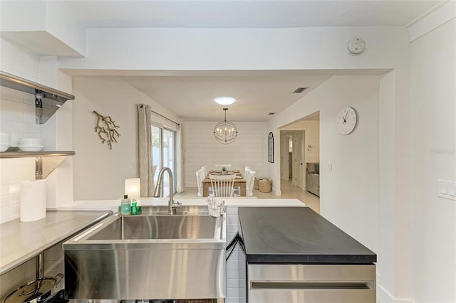 kitchen with visible vents, decorative backsplash, an inviting chandelier, open shelves, and a sink