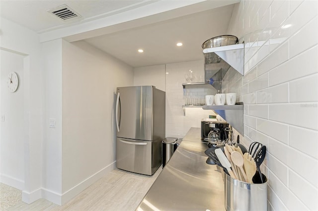 kitchen with visible vents, stainless steel countertops, freestanding refrigerator, open shelves, and recessed lighting