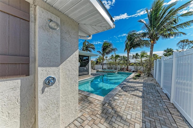 view of pool with a pool with connected hot tub, a fenced backyard, and a patio