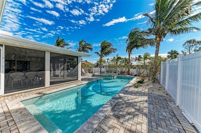 view of pool with a sunroom, a fenced backyard, a pool with connected hot tub, and a patio