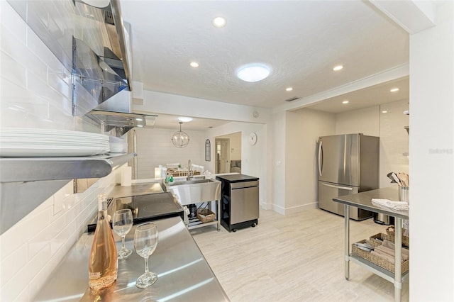 kitchen with recessed lighting, visible vents, freestanding refrigerator, a sink, and a textured ceiling