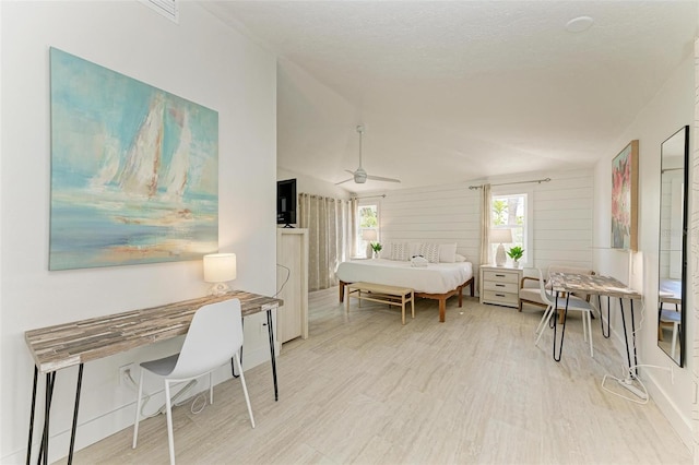 interior space featuring light wood-style floors, vaulted ceiling, and a ceiling fan