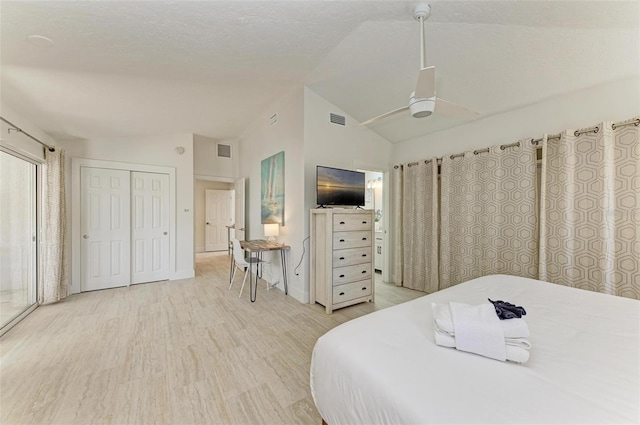 bedroom featuring light wood-type flooring, lofted ceiling, visible vents, and a ceiling fan