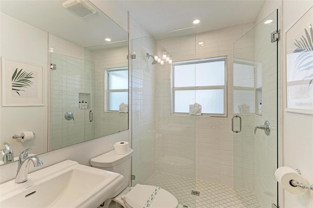 bathroom featuring toilet, a shower stall, visible vents, and a sink