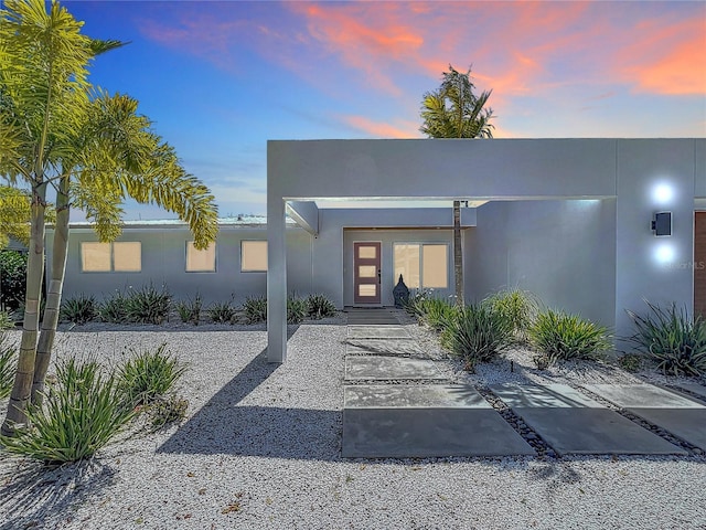 doorway to property featuring stucco siding