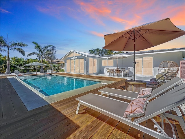 outdoor pool with outdoor dining area and a wooden deck