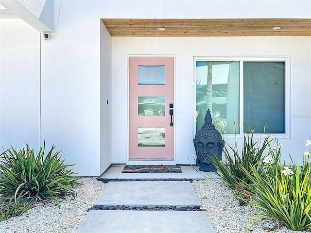 doorway to property featuring stucco siding