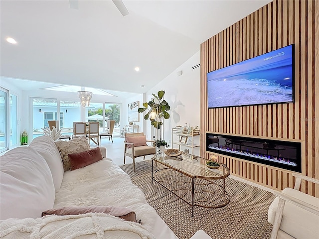 living room featuring recessed lighting, a glass covered fireplace, and vaulted ceiling