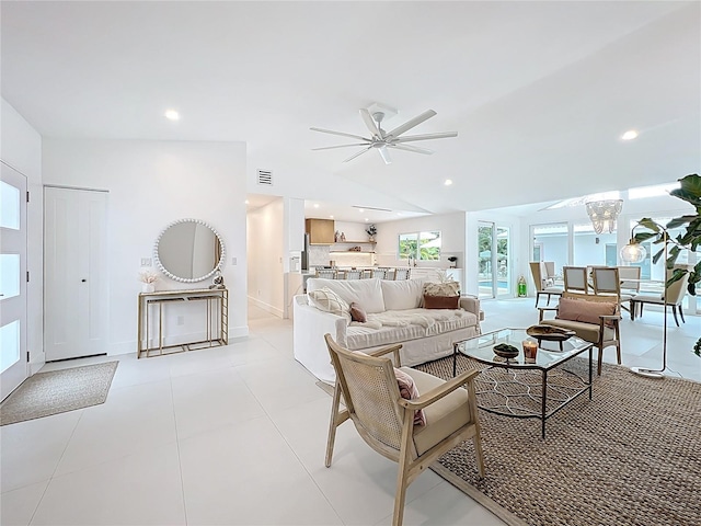 living area featuring light tile patterned floors, recessed lighting, ceiling fan with notable chandelier, visible vents, and baseboards