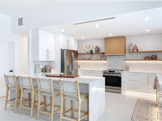 kitchen with open shelves, stainless steel appliances, tasteful backsplash, visible vents, and a kitchen bar