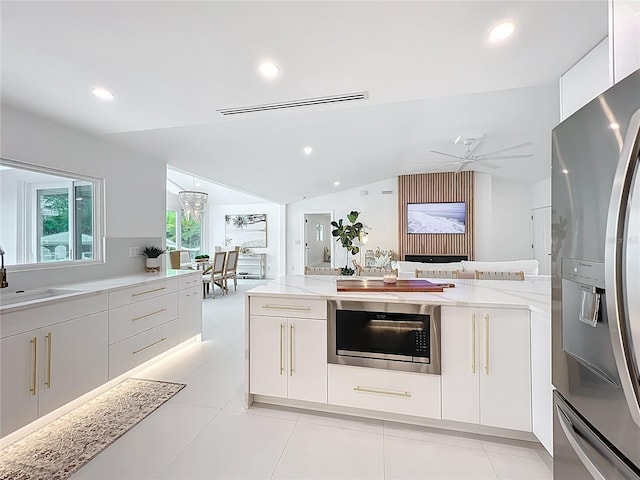 kitchen with lofted ceiling, white cabinets, and stainless steel refrigerator with ice dispenser