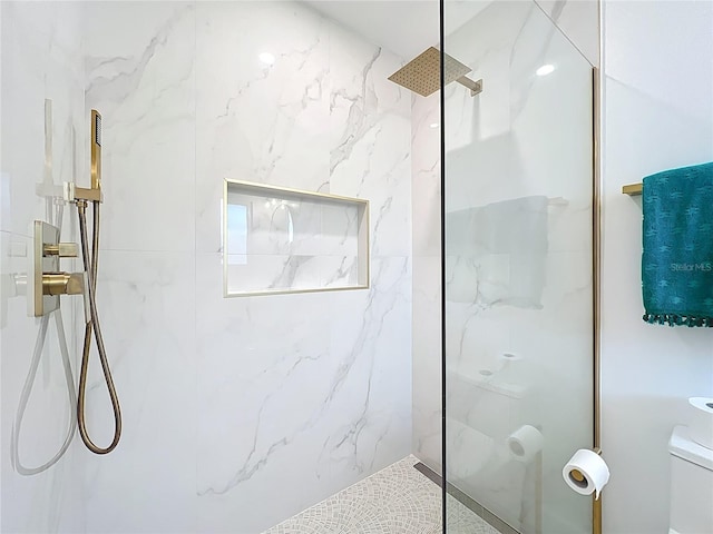 bathroom with a marble finish shower and toilet