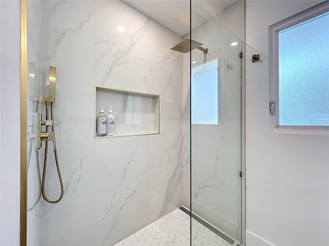 bathroom featuring a marble finish shower