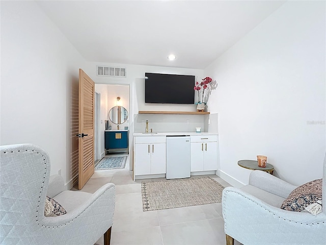 interior space with baseboards, visible vents, and light tile patterned flooring