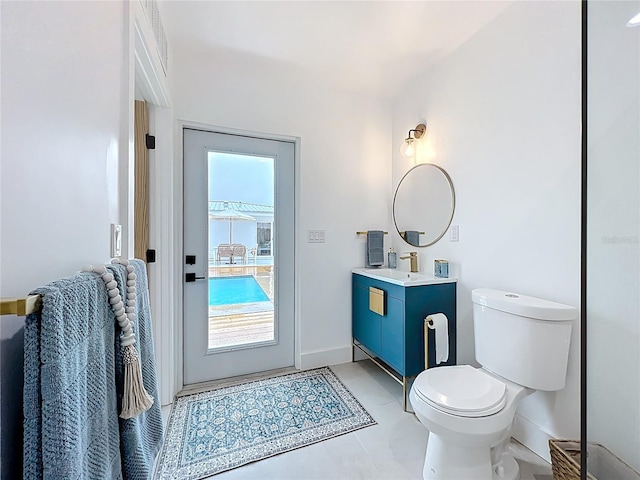 bathroom featuring toilet, tile patterned flooring, vanity, and baseboards