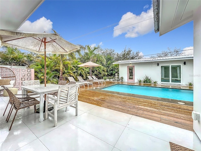 outdoor pool with outdoor dining area and a patio area