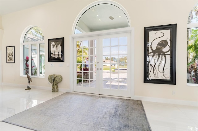 entrance foyer featuring a healthy amount of sunlight, french doors, and baseboards