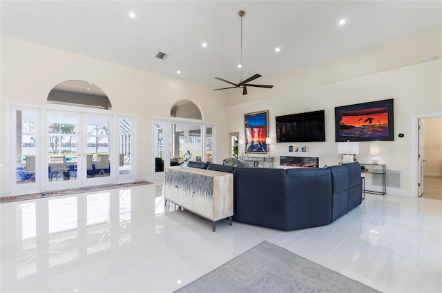 living area featuring visible vents, a towering ceiling, recessed lighting, baseboards, and ceiling fan