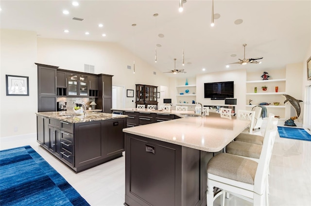 kitchen with a sink, a large island, visible vents, and ceiling fan