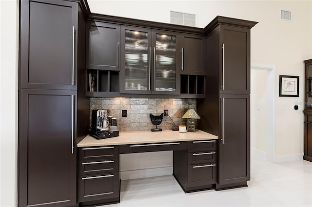 bar featuring tasteful backsplash, visible vents, and built in desk