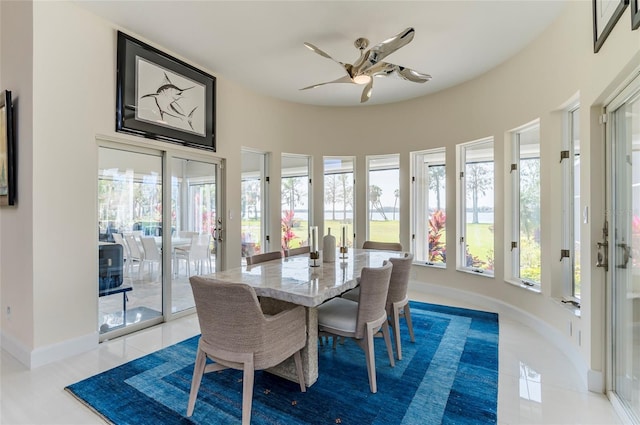 tiled dining room with baseboards and ceiling fan