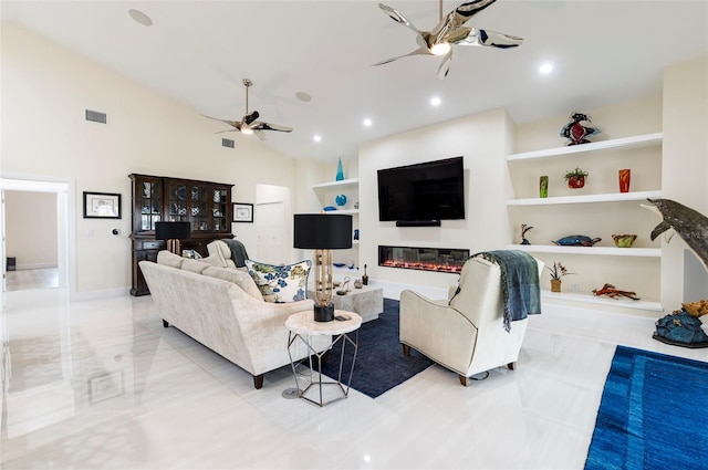 living room featuring a glass covered fireplace, vaulted ceiling, a ceiling fan, and visible vents