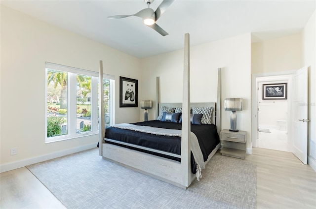 bedroom with connected bathroom, a ceiling fan, light wood-type flooring, and baseboards