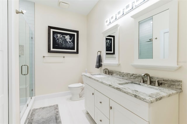 bathroom featuring a sink, baseboards, toilet, and a shower stall