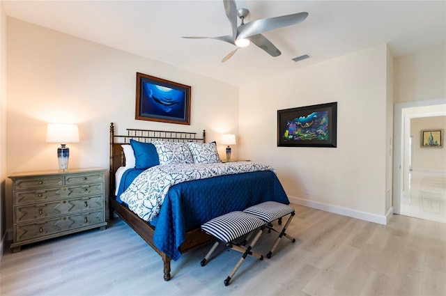 bedroom featuring visible vents, light wood-style flooring, a ceiling fan, and baseboards