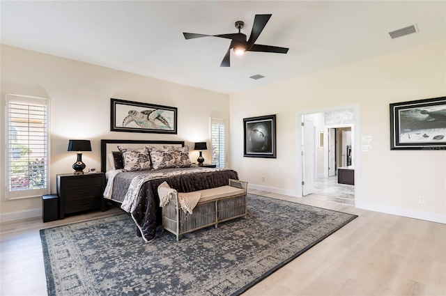 bedroom featuring visible vents, baseboards, and wood finished floors